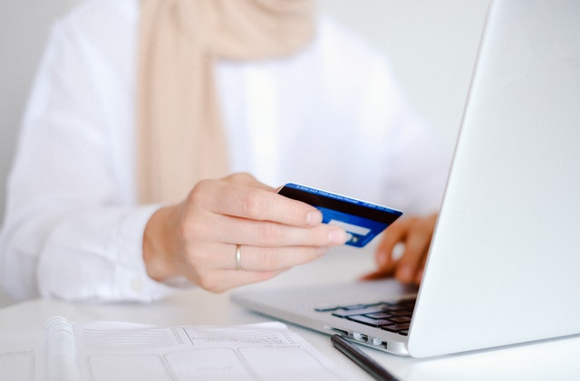 woman in hijab making online purchase with amex card