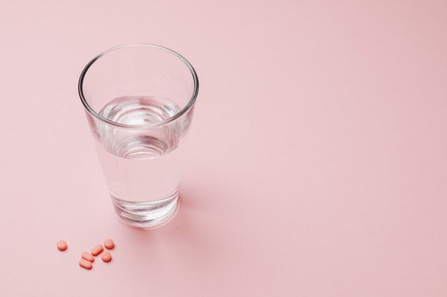 taking medications with a glass of water for prescription adherence