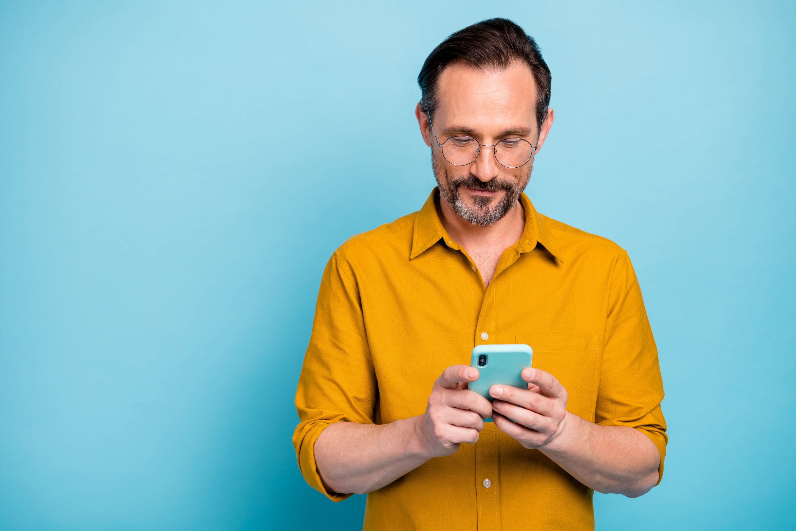 man with beard taking online quiz on iphone next to light blue background