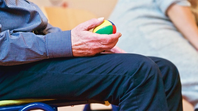 elderly patient taking physiotherapy lessons with a stress ball