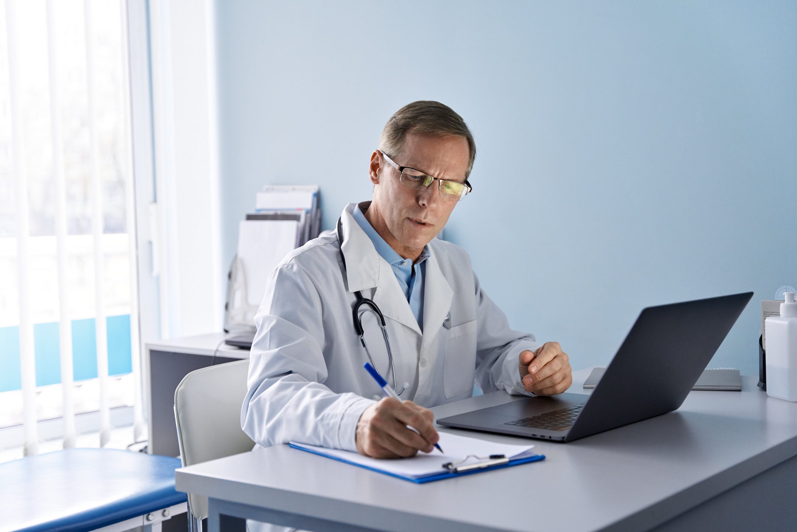 middle aged physician doctor preparing ehr notes from a telemedicine session
