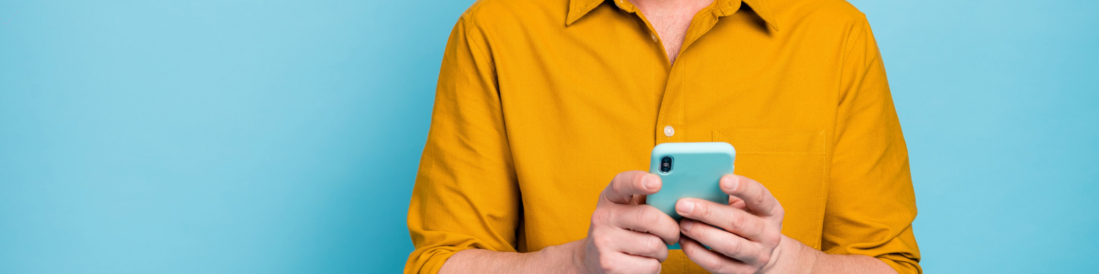 Man in yellow orange shirt holding an iphone 11 ansering online questionnaire