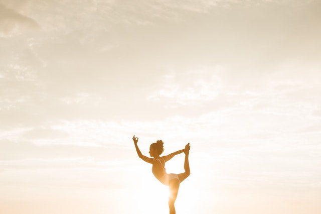 woman practicing yoga poses at dawn