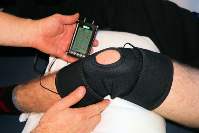 post operative knee surgery patient wearing knee brace in physiotherapy