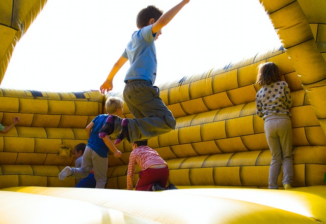 Children jumping around in an inflatable balloon castle 