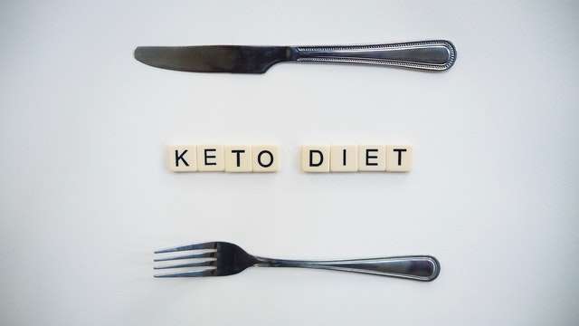 Keto diet spelled out using dice with a knife and fork on either side