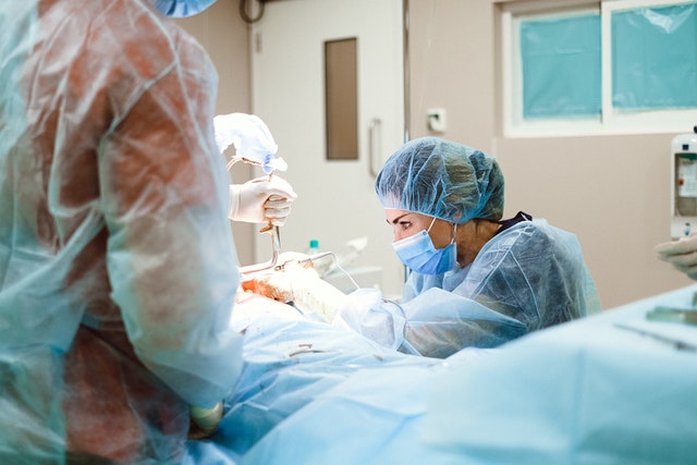 Female orthopedic surgeon performs ACL tendon repair with graft surgery in an operating theatre