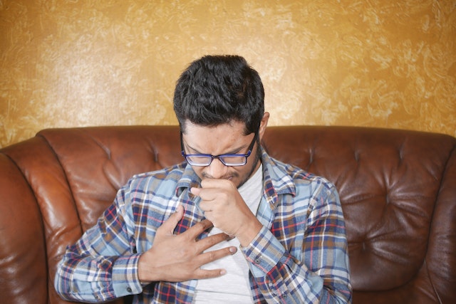 Indian male having a bout of cough and chest tightness due to asthma
